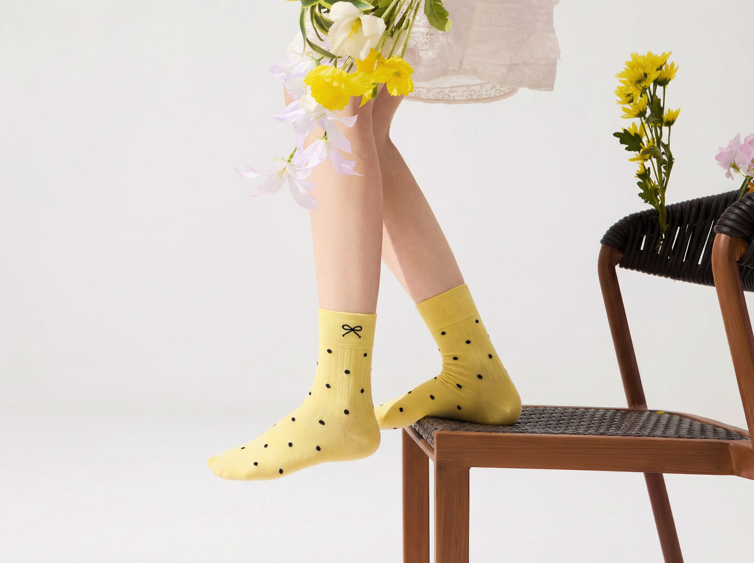 Please swap the yellow ankle-length polka dot socks from the second photo onto the model's feet in the first photo.