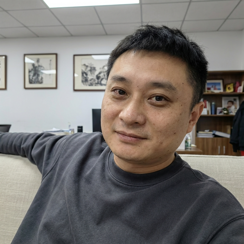 年轻中国男性,35–40 岁人物形象必须强烈、严格参考提供的参考图(reference image)脸型、五官比例、眉眼结构、鼻子与嘴唇形态高度一致,不要生成陌生面孔不要偏离参考图人物不要网红脸。自然好看五官真实并非完美有生活感有记忆点人物呈现高度写实状态允许存在细微真实瑕疵,例如:轻微黑眼圈轻微肤色不均小痘印或细小毛孔不是“完美状态”整体感觉真实、像真实存在的人而不是生成感强的模特长发自然披散略微凌乱不对称。
短发呈现人物采访真实状态自然、随意、有男性魅力表情放松不刻意,管理表情有轻微情绪眼神自然不一直直视镜头偶尔游离像真实聊天中的状态妆容极淡几乎素颜无明显修饰皮肤真实、有毛孔不磨皮不美颜不滤镜穿着休闲衣,而非造型人物坐在沙发上,身体正对镜头上半身明显后倾人物与镜头距离非常近脸部在画面中占比偏大增强真实交流与亲密压迫感
镜头位于人物正前方与人物眼睛同一高度正面构图(frontal shot)非自拍画面中不出现相机或手机。
背景为男性办公室自然、可见真实生活痕迹例如:挂画略有不齐墙面有生活使用感装饰不完全对称整体真实,不“样板间”整体色调偏冷或中性真实色彩不做风格化调色不暖黄不暧昧滤镜不过度科技感偏真实夜晚光线夜晚环境主光源为白色或中性灯光光线略不均匀允许轻微阴影符合真实办公室照明不追求完美补光胸部以上或偏近景构图脸部细节清晰背景轻微虚化画面有真实呼吸感写实摄影风格偏纪录感偏生活影像允许不完美非商业广告非摆拍非棚拍